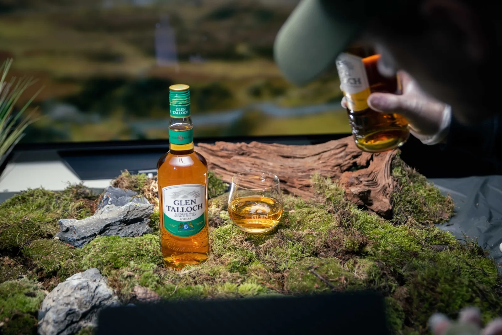 Glen Talloch fles en proefglas op het mos-landschap, met de Schotse hooglanden zacht op de achtergrond