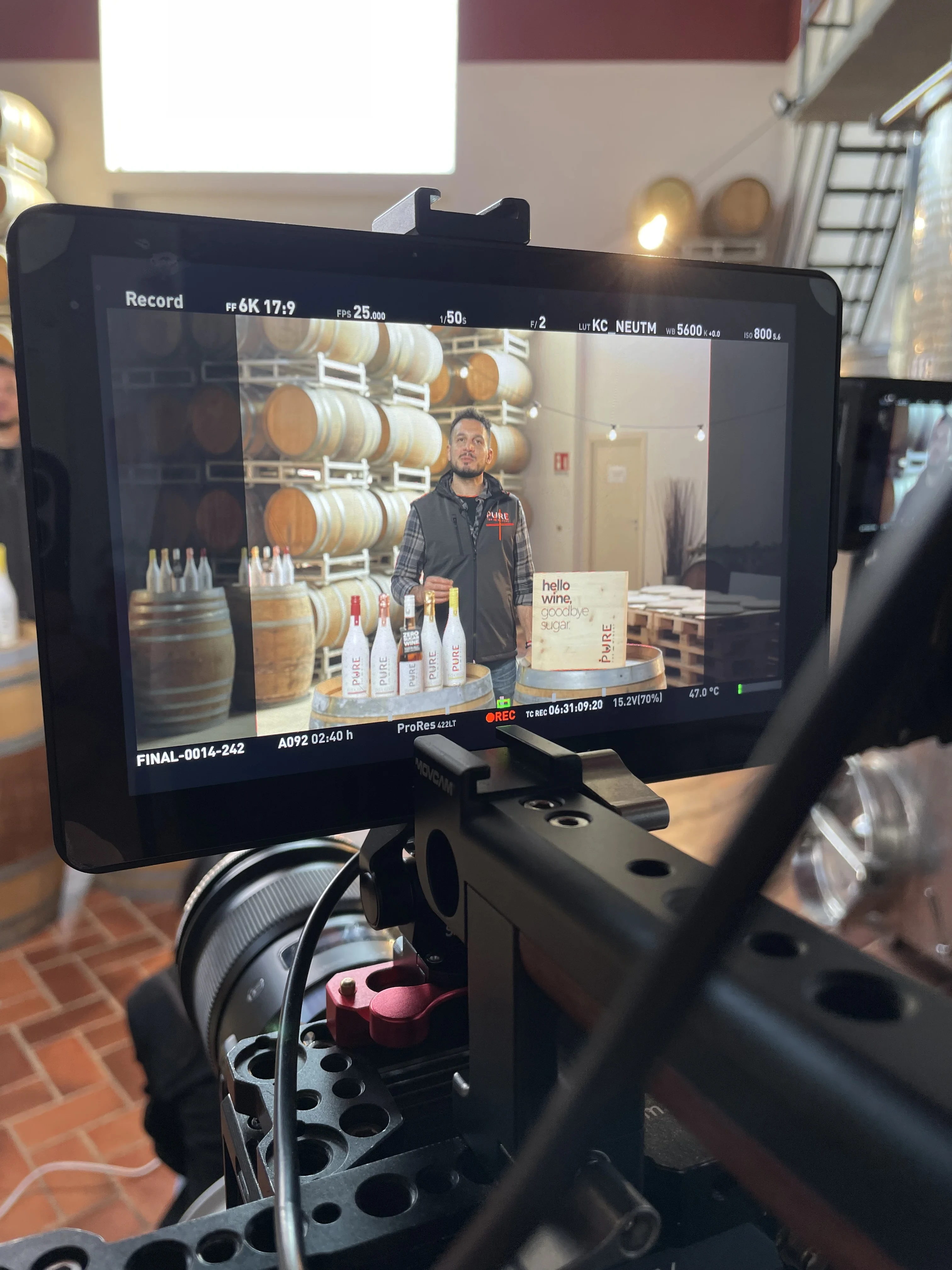 Director's monitor · framing op Daniele in de cellar met de PURE flessen tussen de vaten